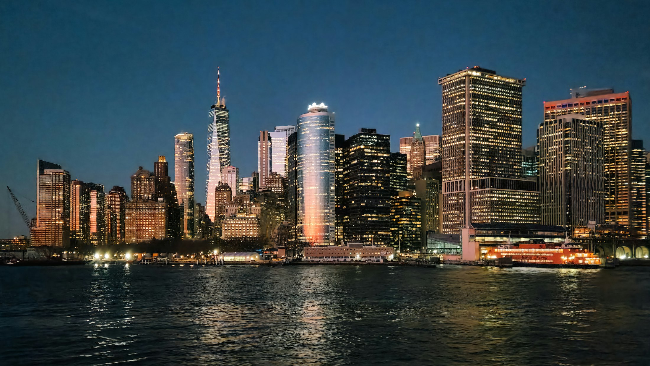 Lower Manhattan skyline at dusk seen from the harbor